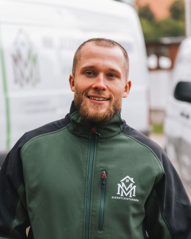Pascal Vagts, Ansprechpartner vor Ort bei MM Dienstleistungen, in Arbeitsjacke vor dem Transporter