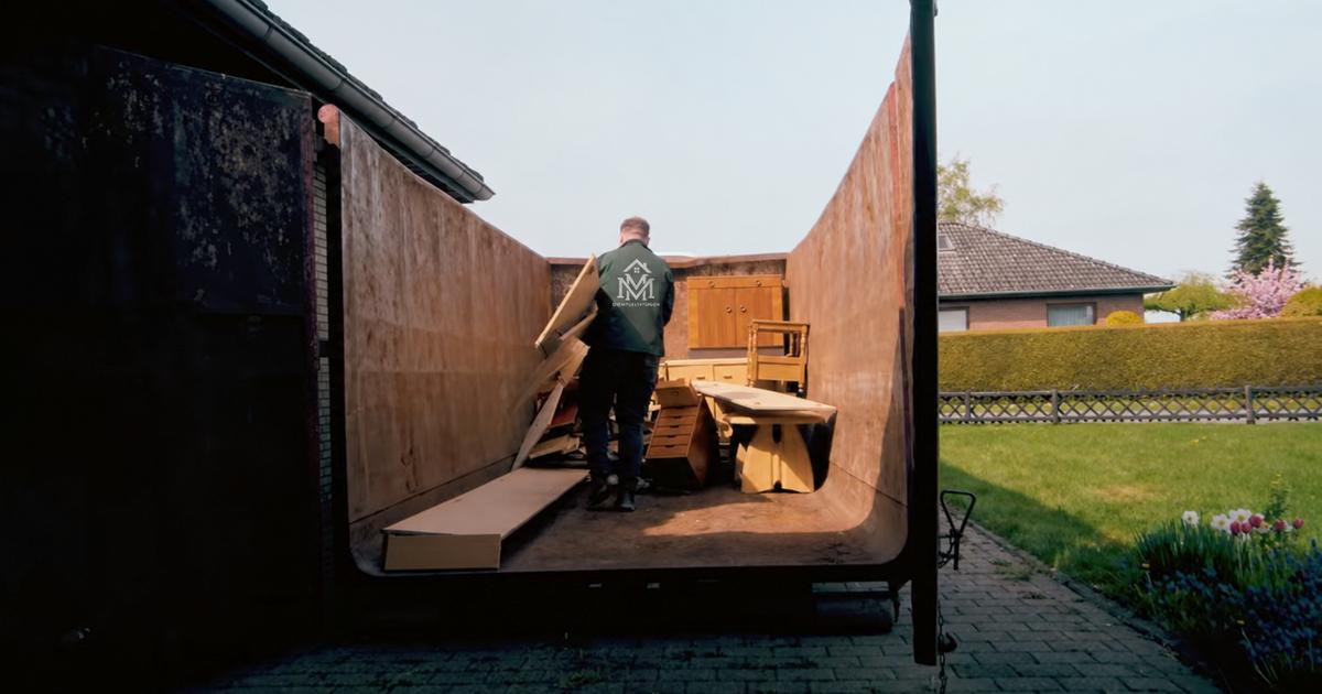 Ein Teammitglied von MM Dienstleistungen lädt Holzteile in einen großen Abrollcontainer in einem Wohngebiet