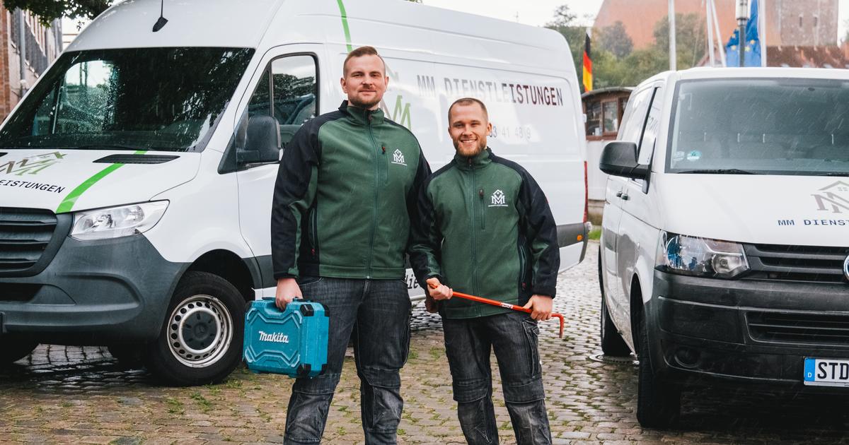 Meik Mroz und Pascal Vagts von MM Dienstleistungen in Arbeitsjacken zwischen ihren beiden beschrifteten Einsatzfahrzeugen